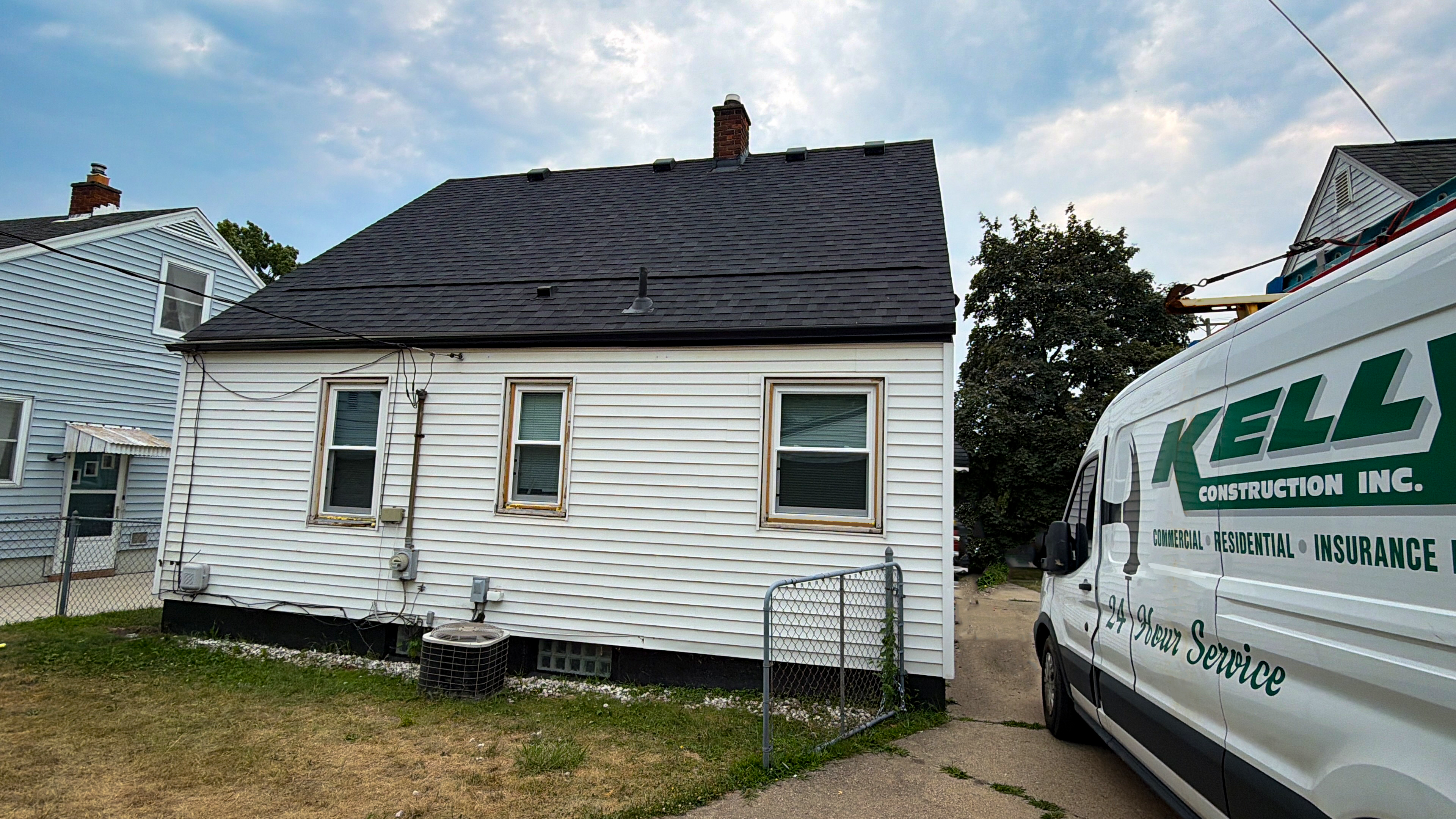 Kelly Construction work van parked at a completed residential roofing job