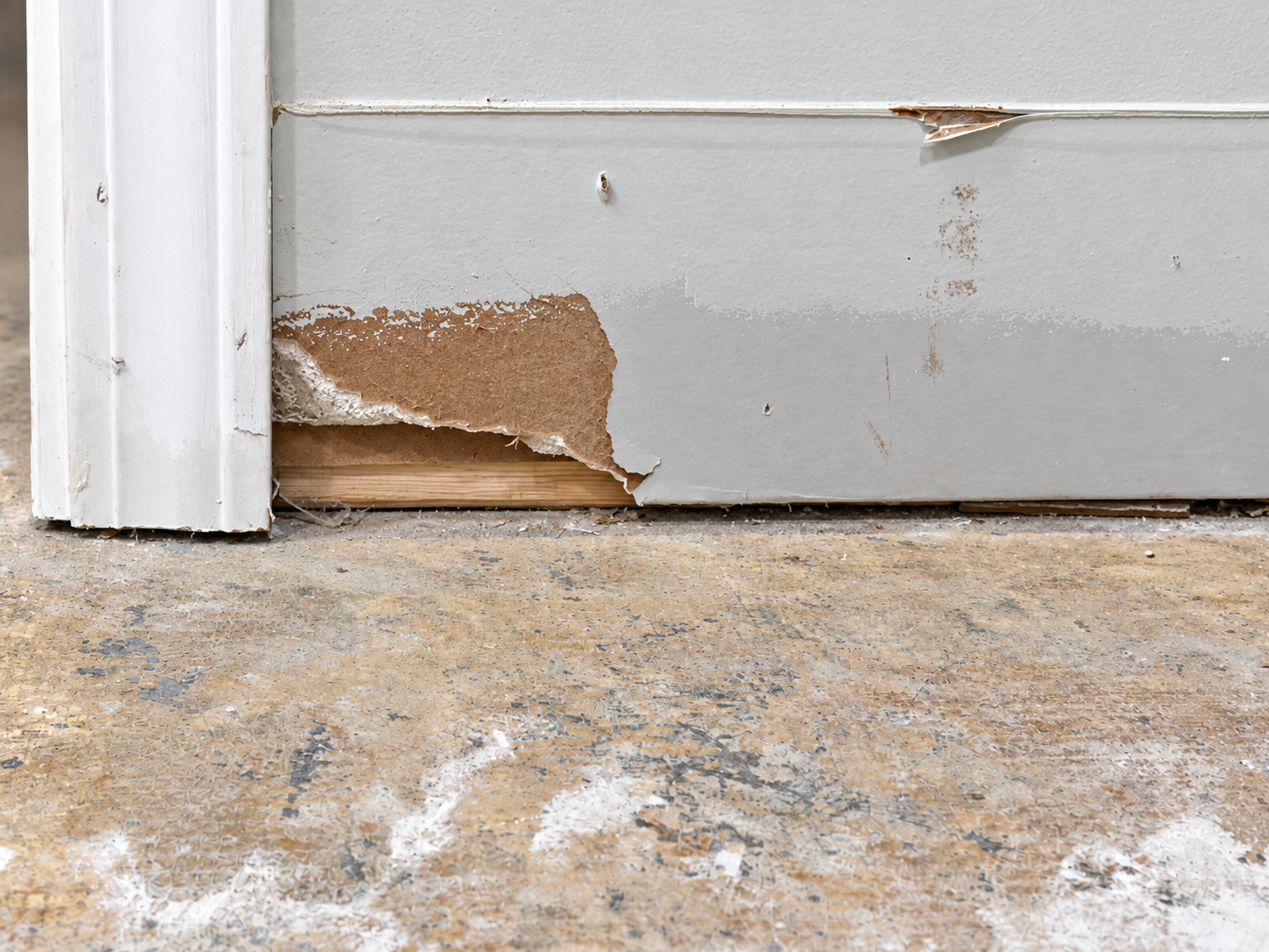 Damaged baseboard and unfinished floor
